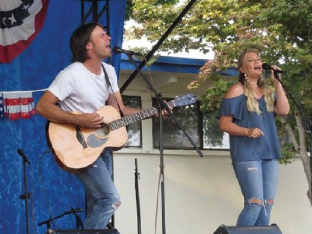 Two musicians performing on the outdoor stage at the Polk County Fair